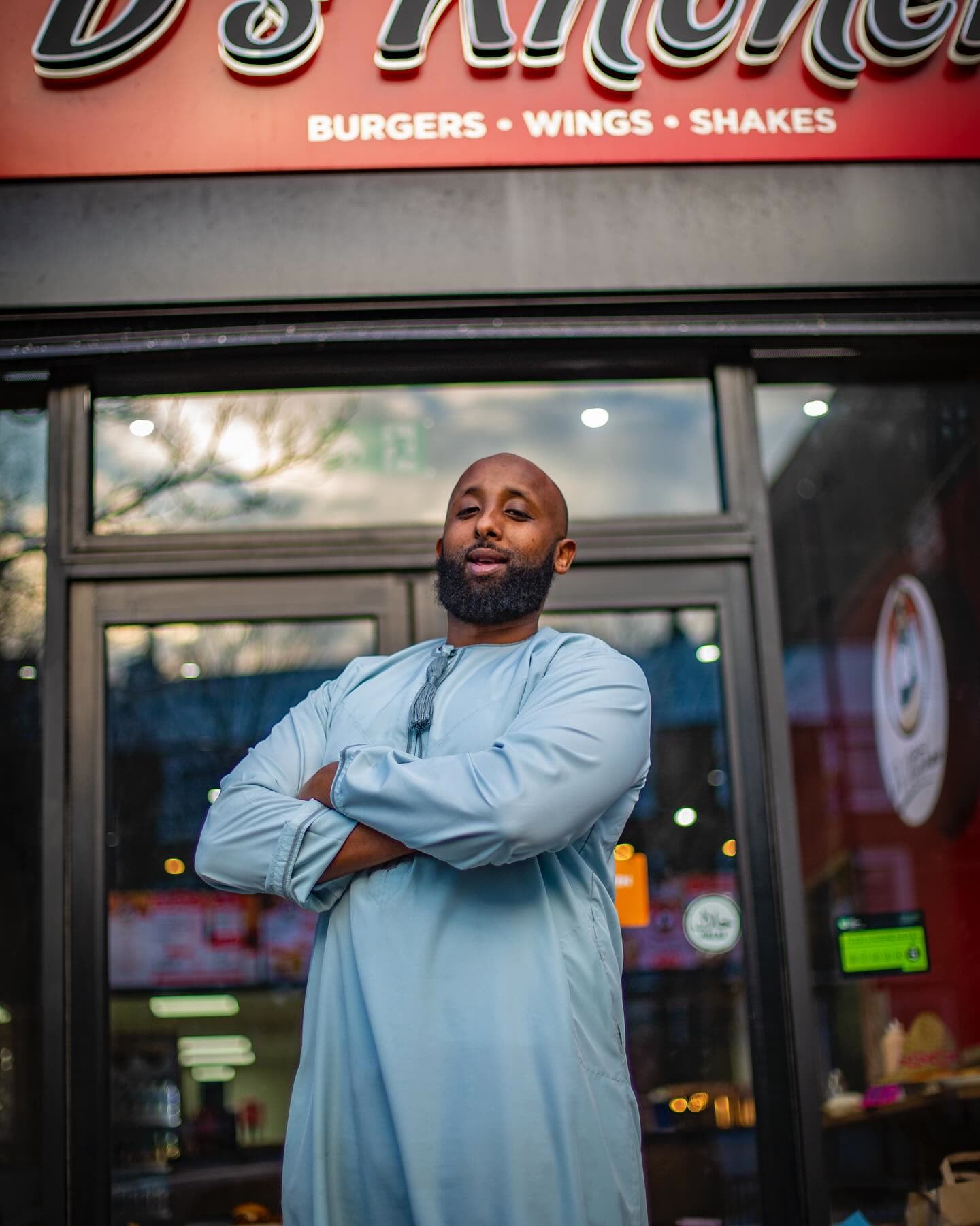 Arms crossed at the door of a D’s Kitchen shop