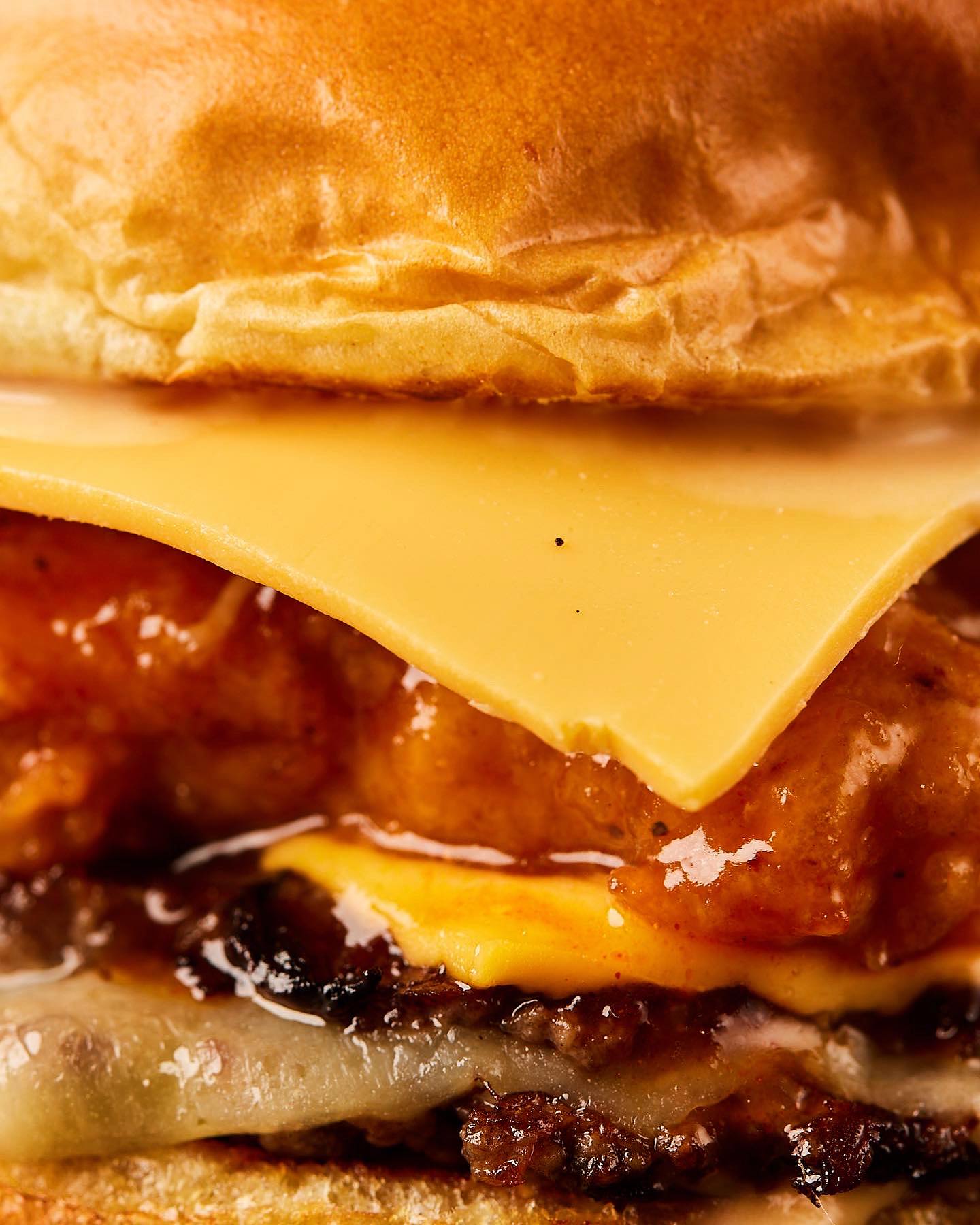 Melted cheese, glazed fried chicken and a smashed patty stacked in a brioche bun