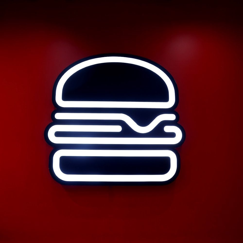 Neon burger sign glowing on the shop’s red wall